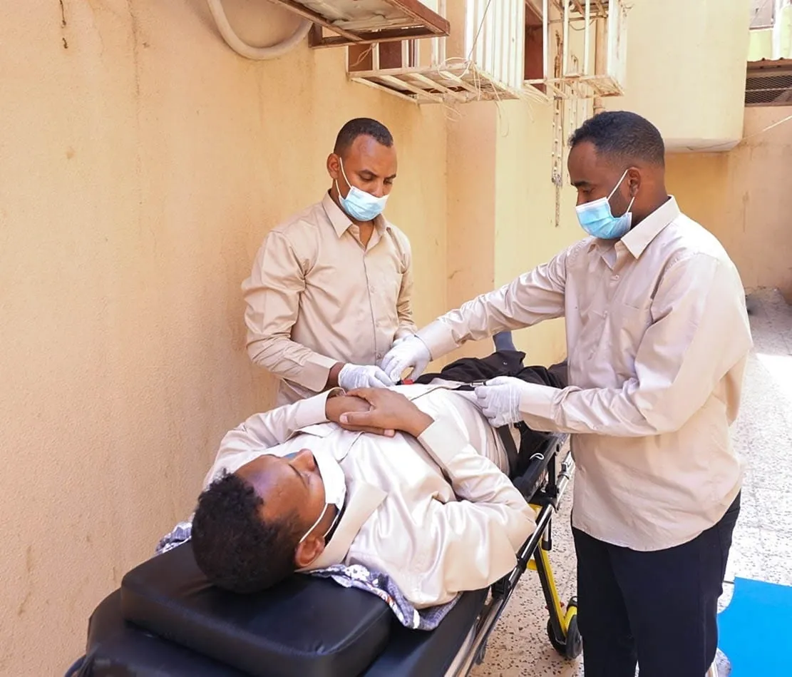 مساعد من عون الدرب يرافق المستفيد ويقدّم له المساعدة أثناء النقل.